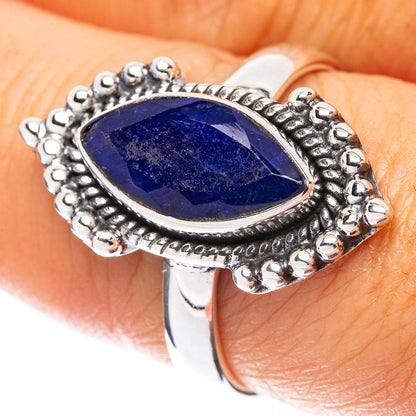 Oval blue gemstone sterling silver ring with ornate beaded bezel, close-up top view