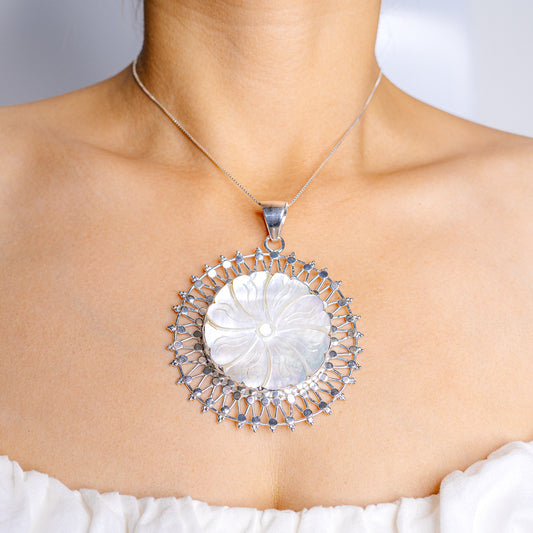 Sterling silver mother-of-pearl pendant with round shell center and blue stone halo