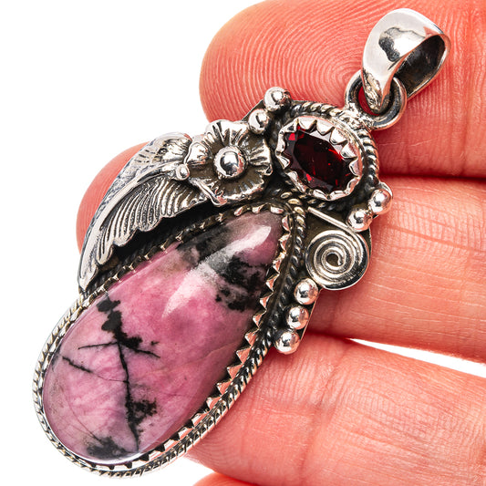 Sterling silver rhodonite teardrop pendant, visible bail and red gemstone accent