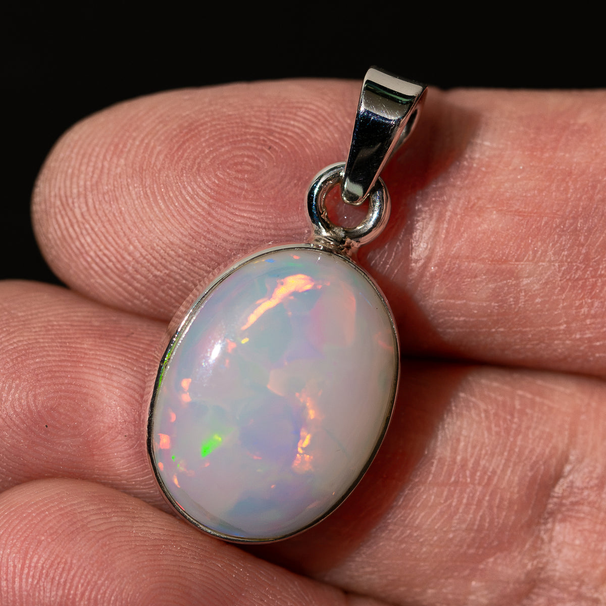 Oval opal pendant in .925 sterling silver bezel with colorful iridescent play-of-color