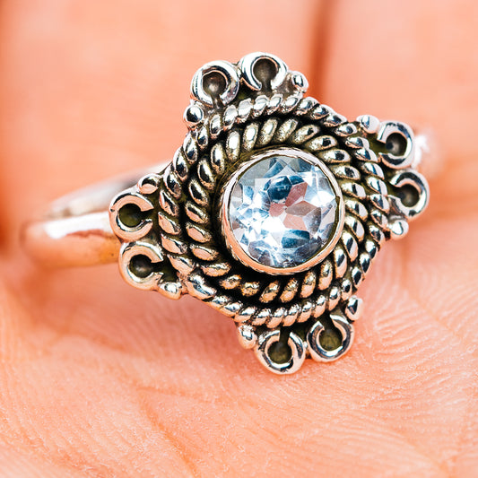 Sterling silver filigree ring with round light-blue gemstone, raised bezel detail