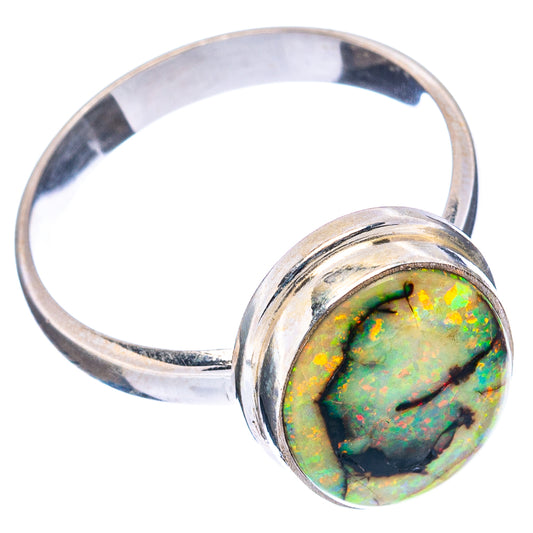 Oval opal set in sterling silver bezel on ring band, green opal with dark spots