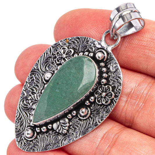 German silver teardrop pendant with green aventurine stone on ornate filigree, in hand
