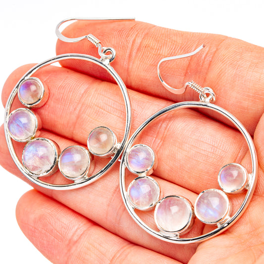 Silver hoop earrings with pink-lavender moonstone cabochons, close-up on hand