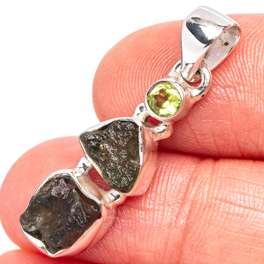 Sterling silver pendant close-up: round green peridot bezel with rough moldavite