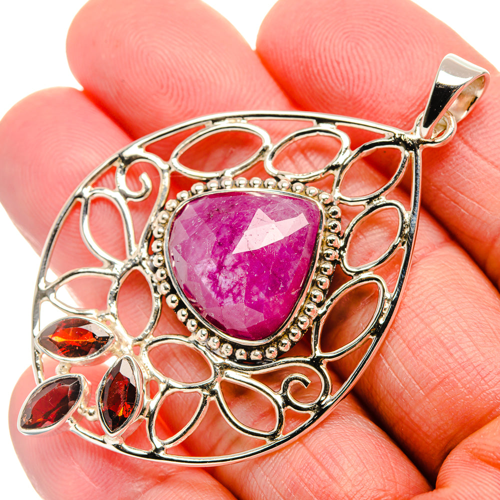 Sterling silver ruby pendant with oval pink gemstone, ornate openwork frame, top bail