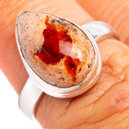 Sterling silver fire opal ring with oval red-orange stone, close-up view
