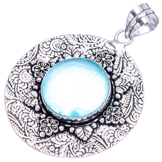 Teardrop-shaped German silver pendant with intricate floral etching and blue onyx center.