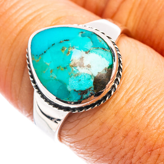 Oval turquoise cabochon sterling silver ring with rope-like bezel, close-up on finger