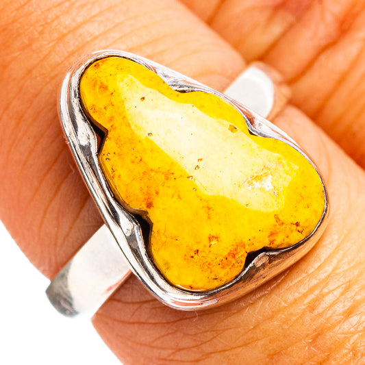Sterling silver ring with bezel-set yellow oval stone, heart-shaped setting