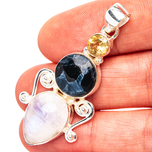 Sterling silver gemstone pendant with round blue-black, round yellow, and oval pale stones