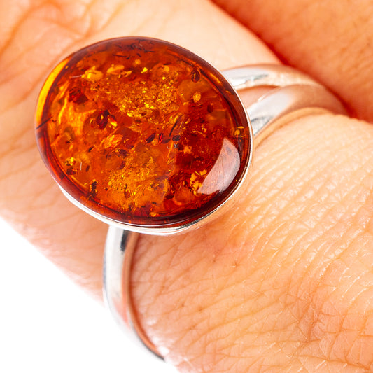 Oval amber cabochon set in polished .925 sterling silver band on finger