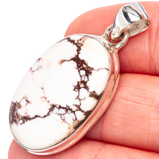 Oval wild horse jasper cabochon pendant in .925 sterling silver bezel, held on fingertip