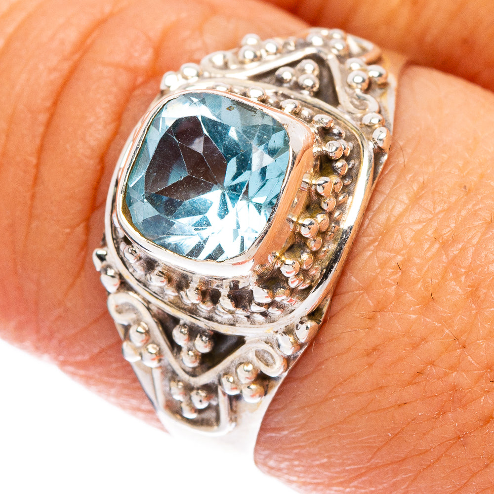 Sterling silver blue topaz ring close-up with oval stone, engraved bezel and bead details