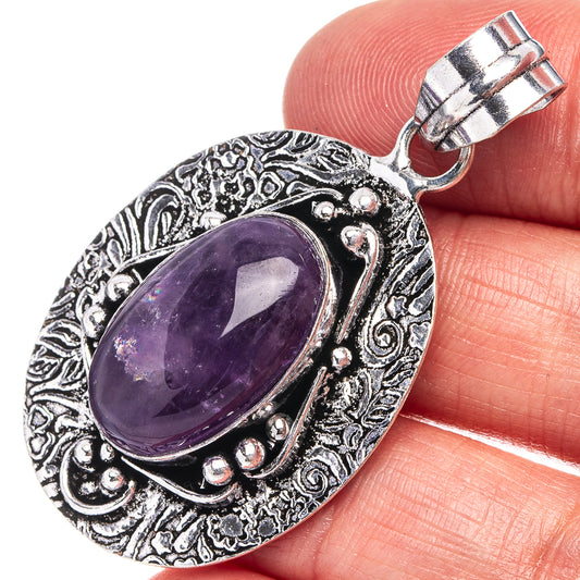 Amethyst oval pendant in German silver with ornate frame and hanging loop.