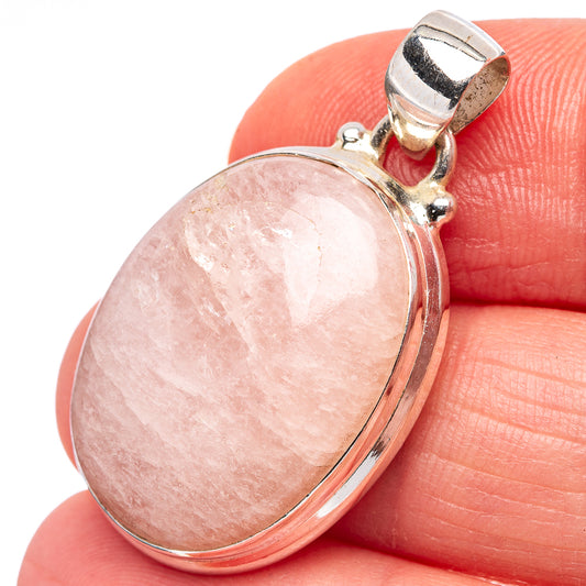 Oval rose quartz pendant on finger with hinged bail and polished .925 sterling silver frame