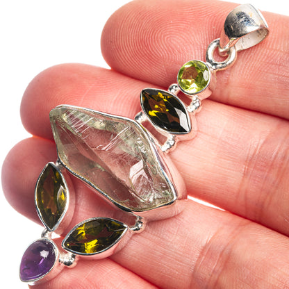 Rough aquamarine, green and purple gemstone pendant on 925 silver bail, close-up