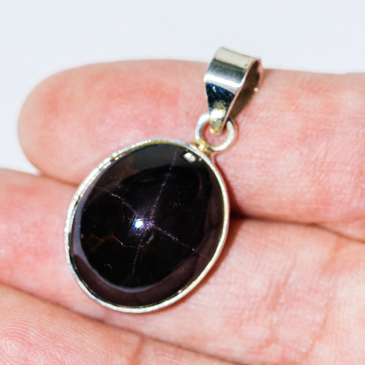 Round sterling silver gemstone pendant with dark cabochon and bail loop