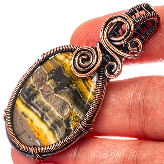 Oxidized copper wire-wrapped oval jasper pendant with spiral coils and bezel frame