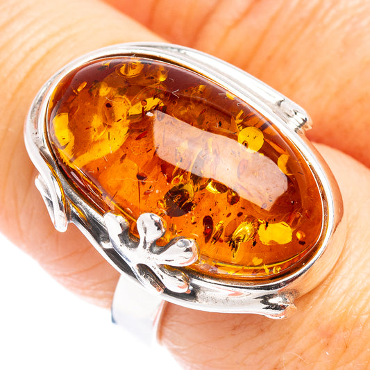 Sterling silver ring with oval amber cabochon and leaf inclusions, adjustable band
