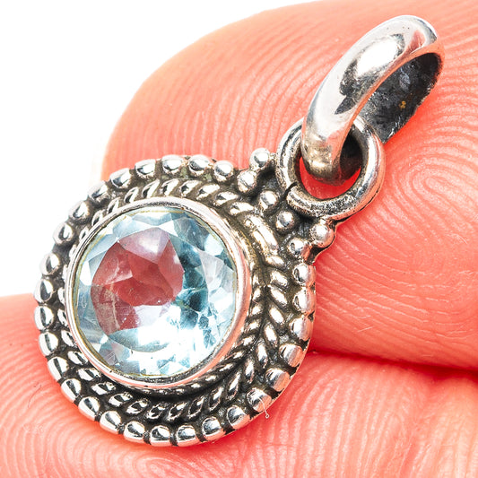 Sterling silver pendant with blue topaz round center and ornate bead border