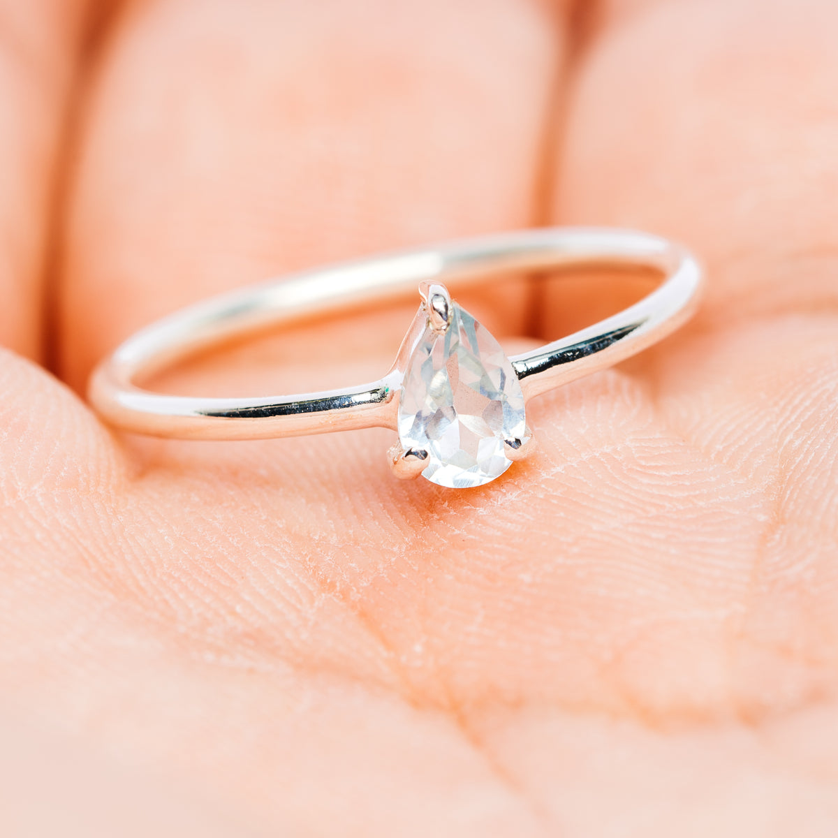 Sterling silver stackable ring with oval light-blue gemstone center prong detail