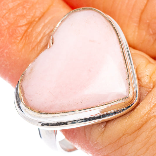 Heart-shaped pink opal ring with polished sterling silver band on finger