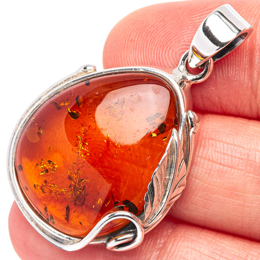 Red amber teardrop pendant with silver swirl setting and hinged bail, .925 sterling silver