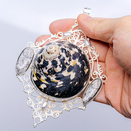 Sterling silver pendant with round dark shell cabochon, oval side stones, pearl accents