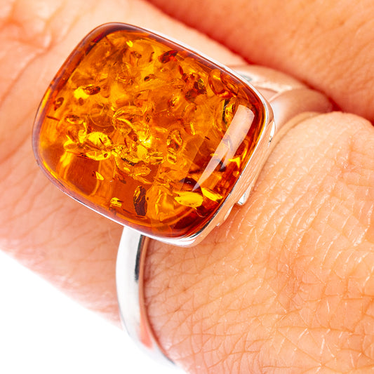 Oval amber gemstone ring with fiery orange center in silver setting