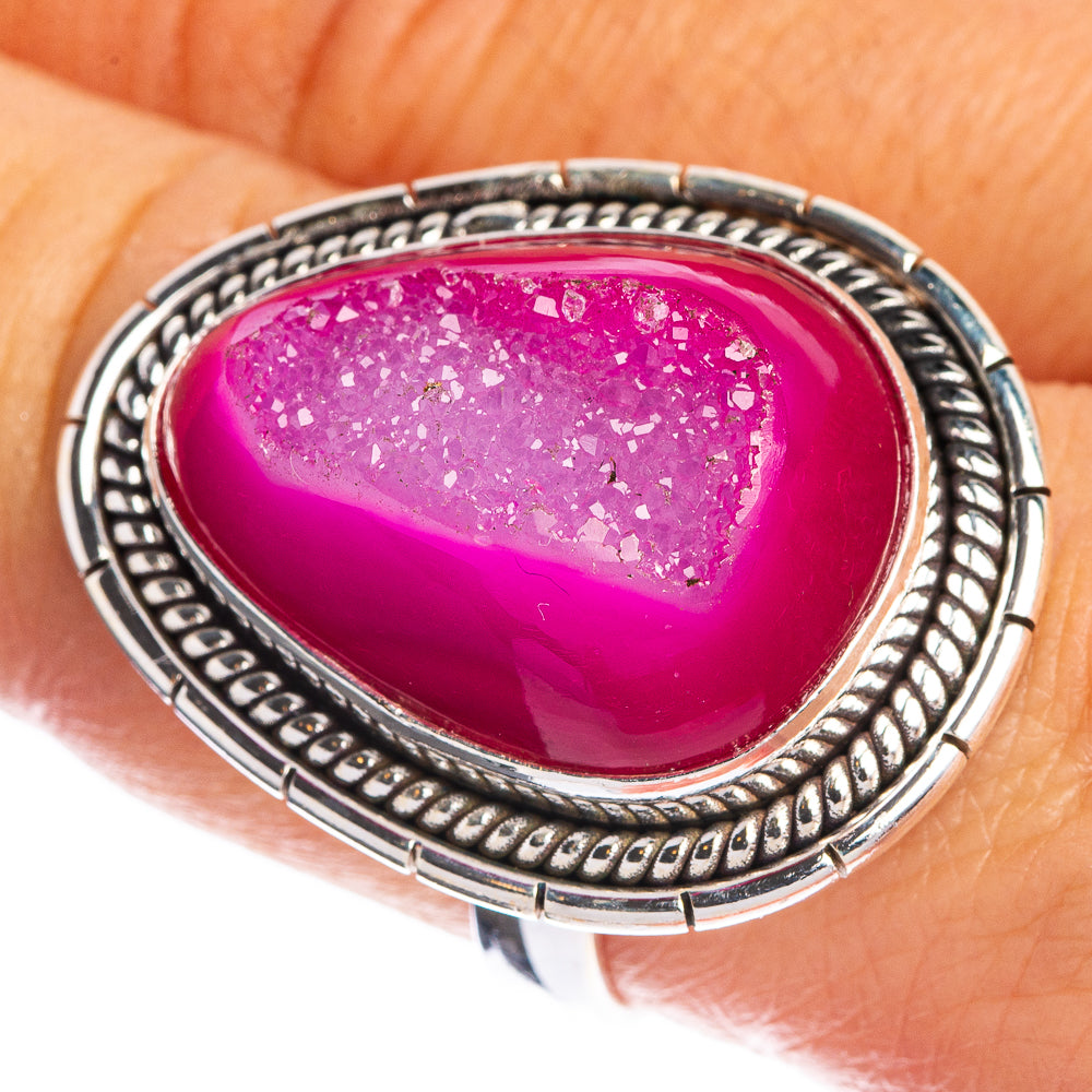 Large oval pink druzy statement ring on finger, ornate silver border and setting
