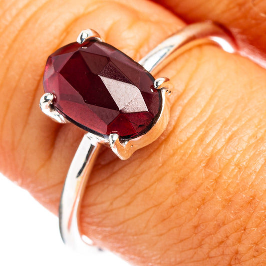 Sterling silver ring with cushion-cut faceted dark red garnet and open prongs