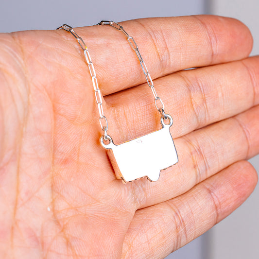 Sterling silver necklace with square pendant and bail on link chain, close-up