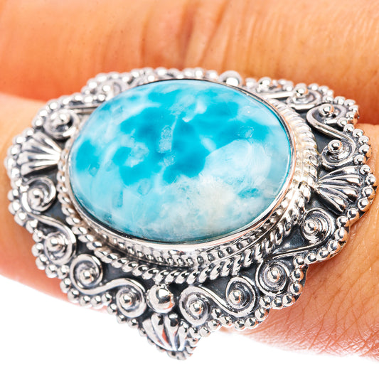 Sterling silver Larimar ring on hand, oval blue stone in detailed scrollwork frame