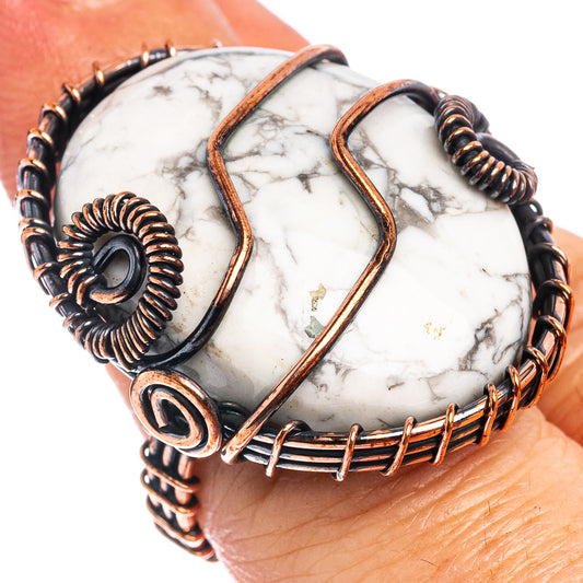 Howlite wire wrap ring on hand, oval white stone with copper rails and dark coils