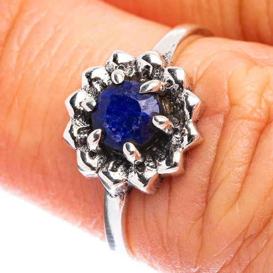 Sterling silver ring with round blue gemstone and clustered bezel prongs on hand