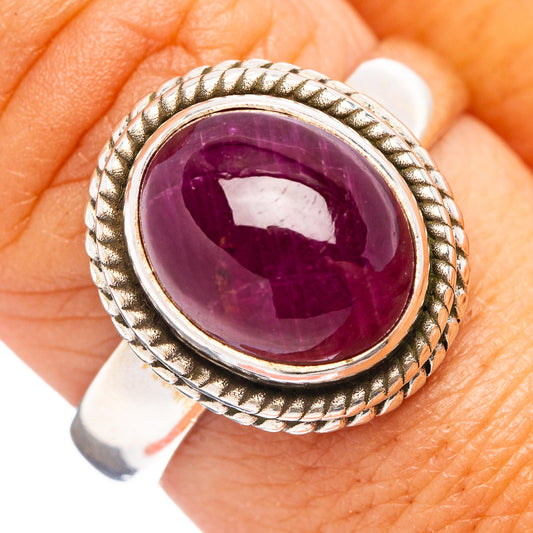Sterling silver ruby ring with oval deep purple cabochon and rope border bezel