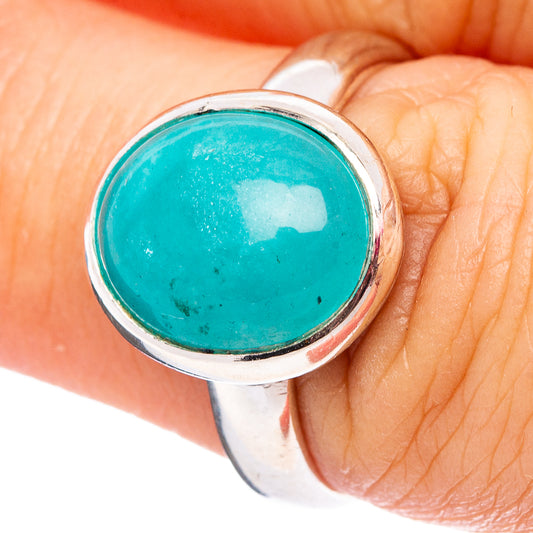 Turquoise round cabochon gemstone ring in silver bezel on hand
