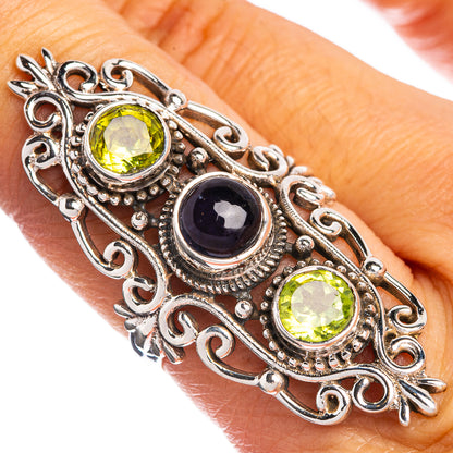 Sterling silver gemstone ring on finger, oval green stones and dark blue center gem