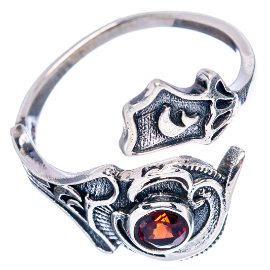 Sterling silver adjustable ring with red garnet center and ornate heart-like filigree
