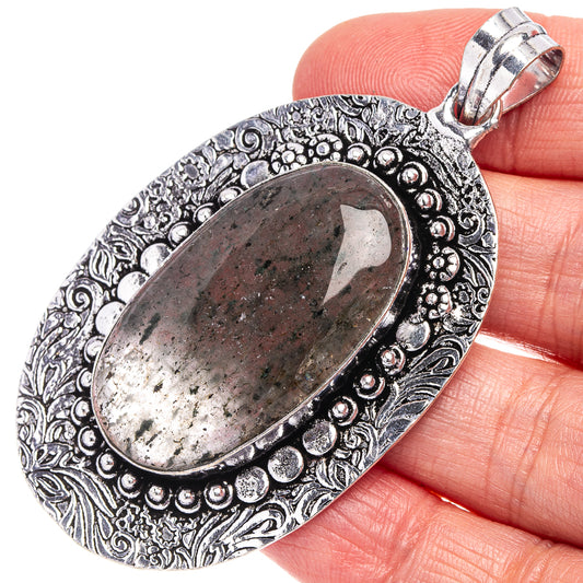 German silver oval pendant with green-gray moss agate cabochon and ornate border bail