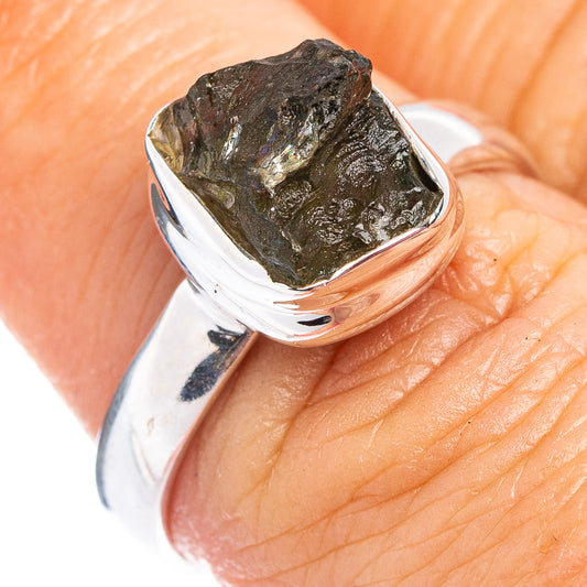 Sterling silver ring close-up on textured dark green moldavite stone bezel