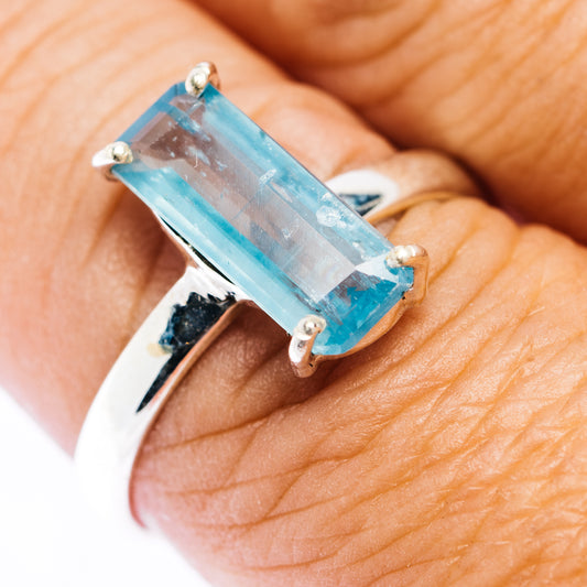 Sterling silver ring with prong-set light-blue baguette gemstone on hand