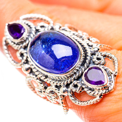 Ornate sterling silver ring with oval blue gemstone and two round purple stones