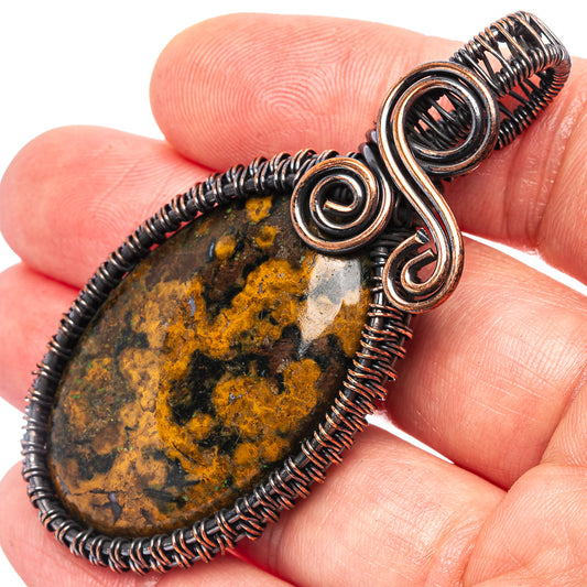 Oxidized copper wire wrap pendant detail with oval agate stone and spiral coils