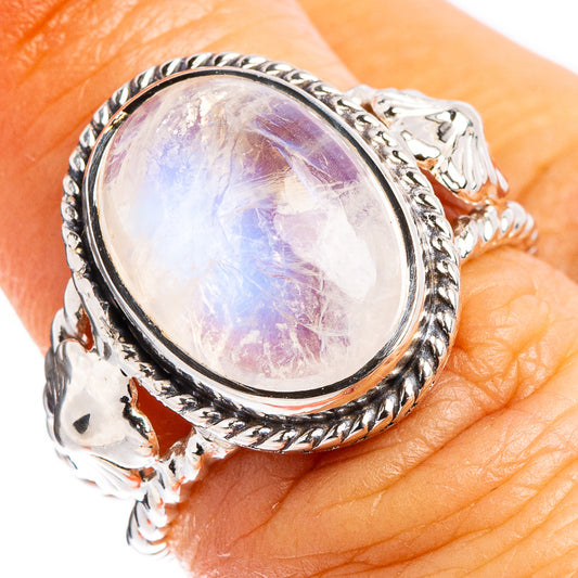 Oval moonstone ring with sterling silver bezel showing rainbow-lavender sheen on finger
