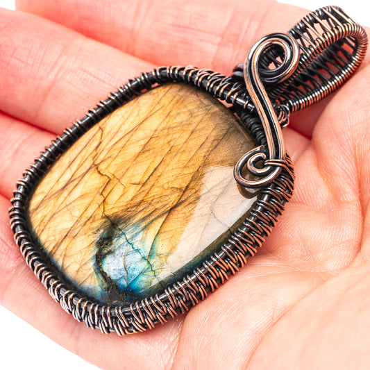 Labradorite wire wrap pendant with oxidized copper frame and blue-gold stone