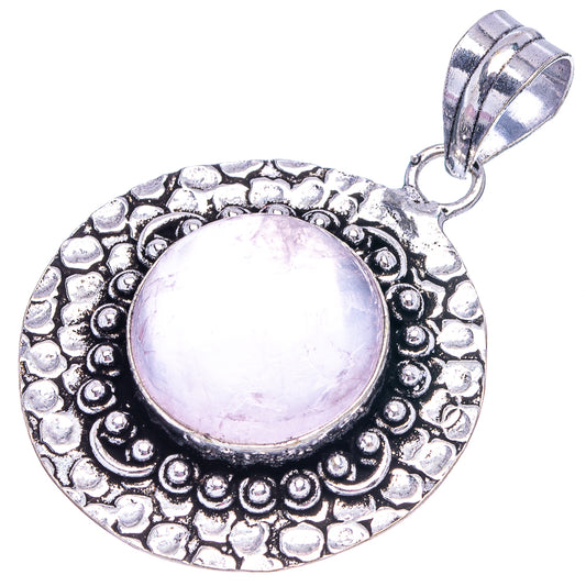 German silver round pendant with engraved border and pale rose quartz cabochon