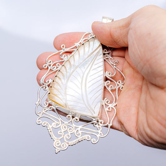 Mother-of-pearl pendant with leaf-vein detail and ornate sterling silver setting