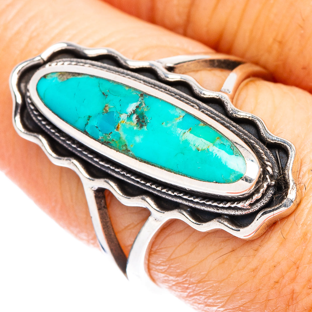 Sterling silver turquoise ring with long oval stone, scalloped frame, on finger